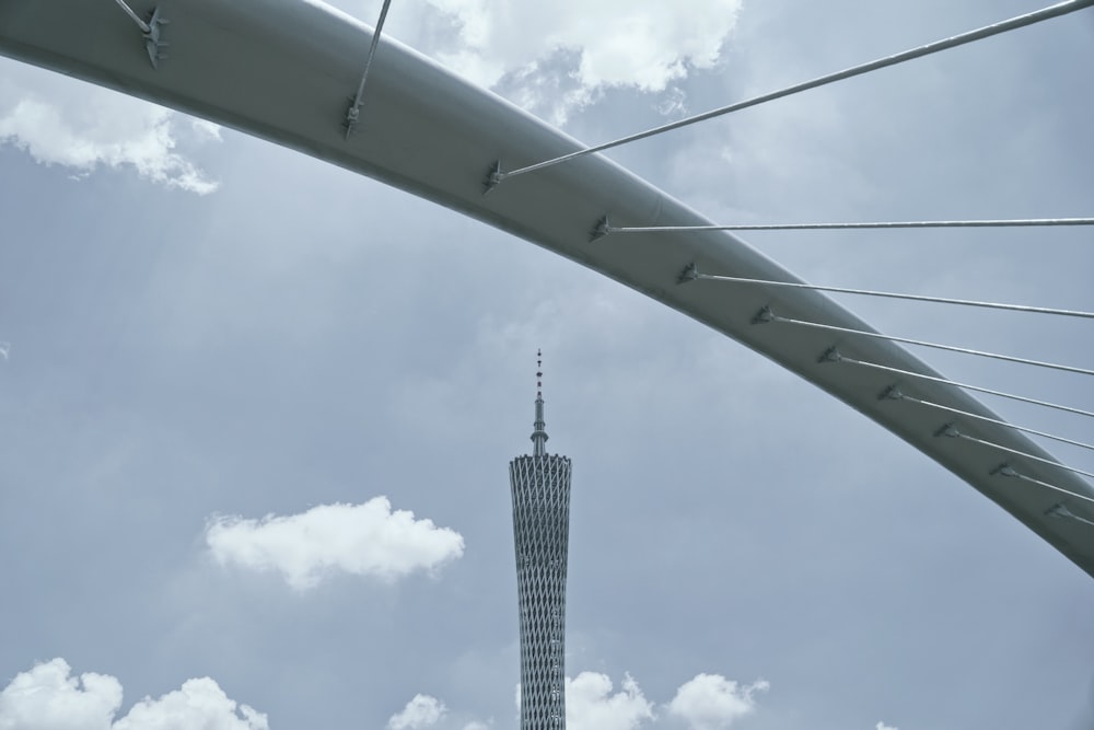 a very tall tower towering over a city under a cloudy sky