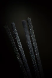 Close-up of rich, dark agarwood chips arranged artistically on natural fabric.