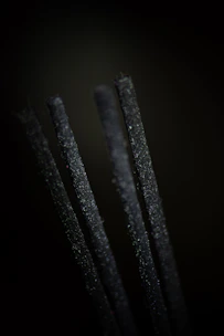 Close-up of rich, dark agarwood chips arranged artistically on natural fabric.
