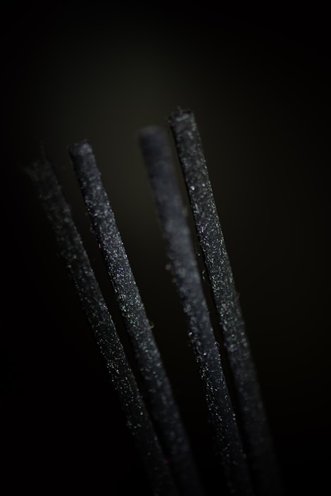 Close-up of natural dhoop sticks arranged on a rustic wooden surface with soft sunlight filtering through.