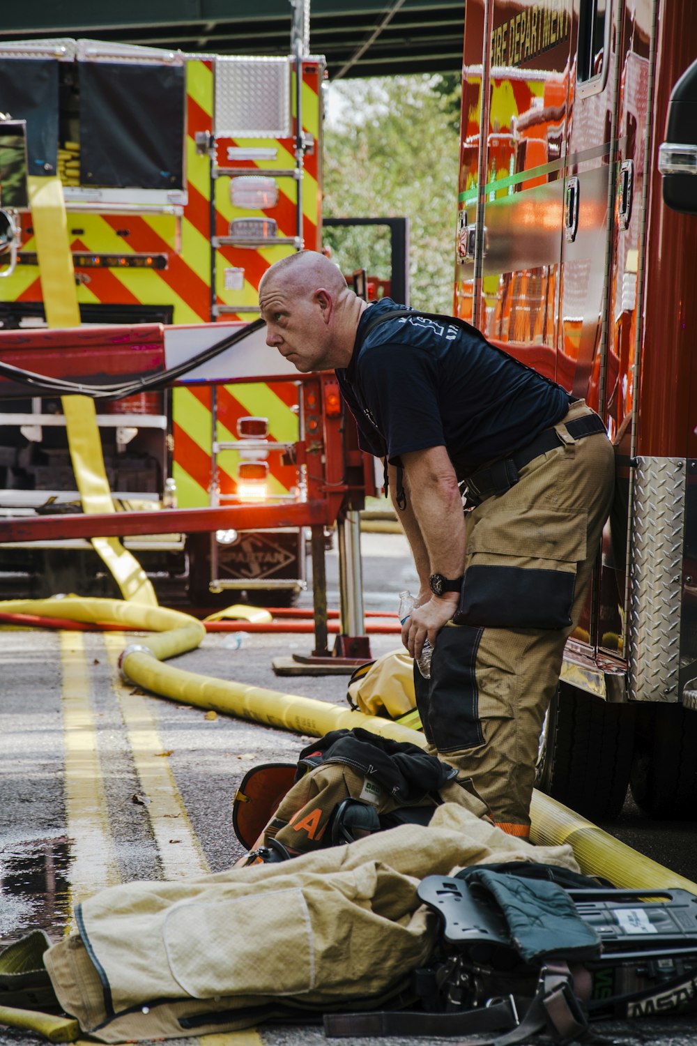 Un pompiere in piedi accanto a una manichetta antincendio