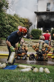 a group of firemen standing around a fire hydrant