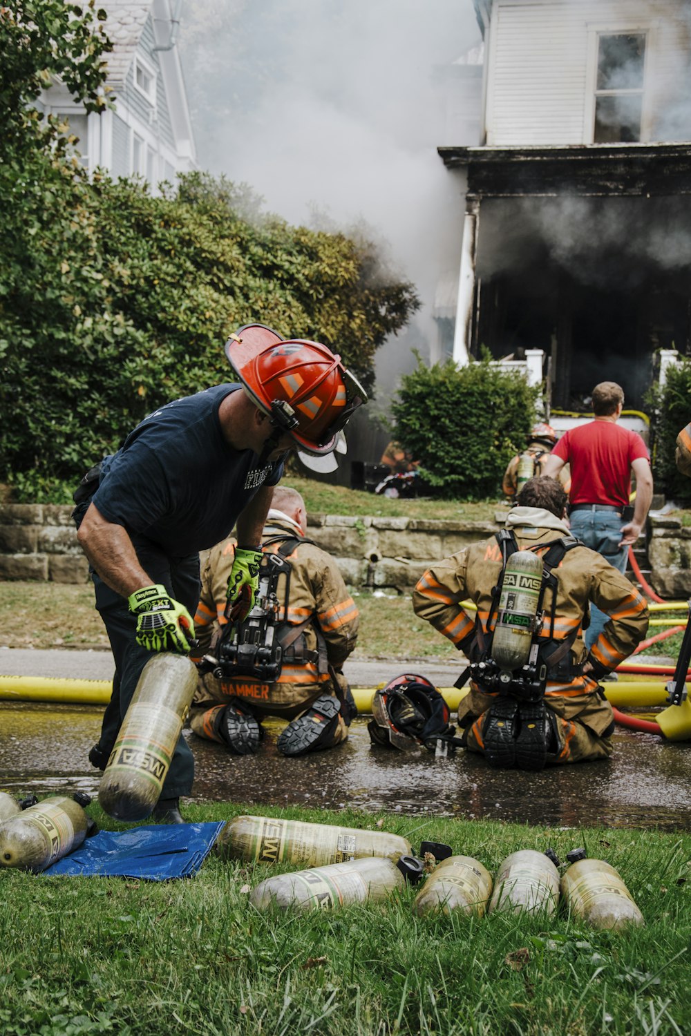 Un grupo de bomberos parados alrededor de una boca de incendios