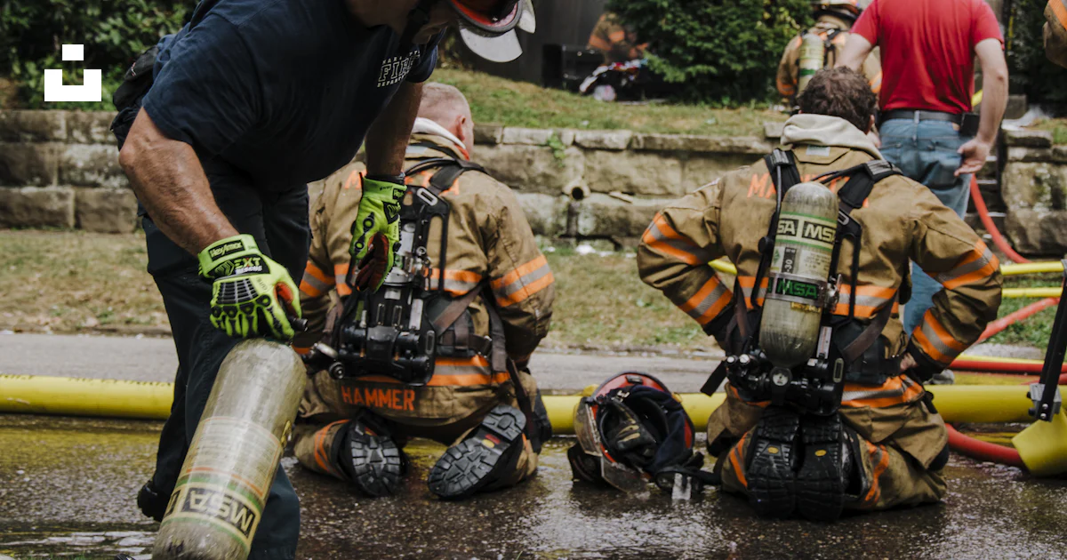 A Group Of Firemen Standing Around A Fire Hydrant Photo Free Marietta a-group-of-firemen-standing-around-a-fire-hydrant-photo-free-marietta