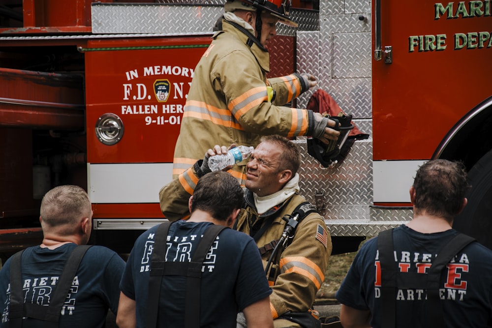 a group of firefighters standing in front of a fire truck