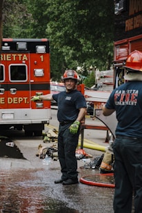 a couple of men standing next to a fire truck