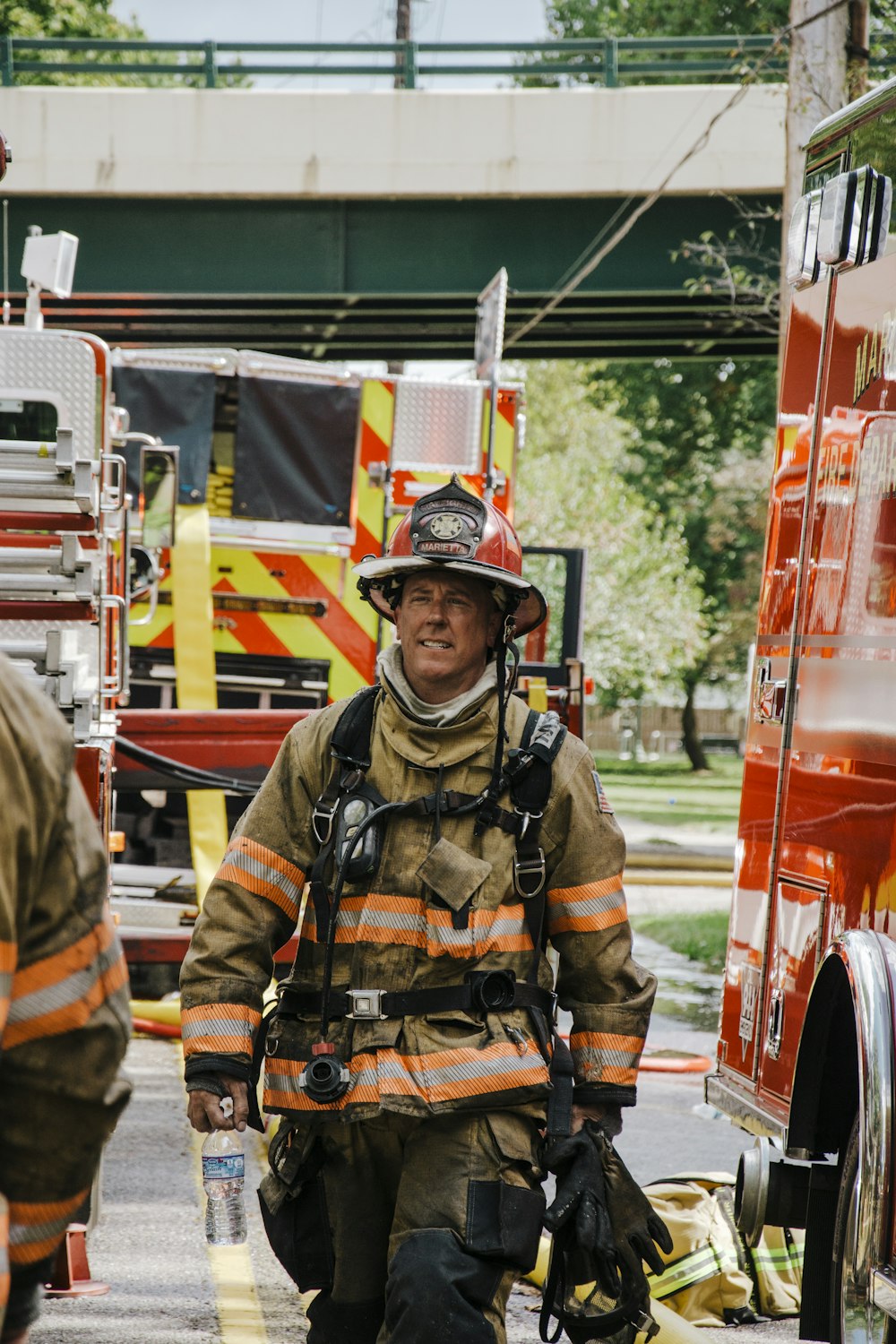 a fireman walking down a street next to a fire truck