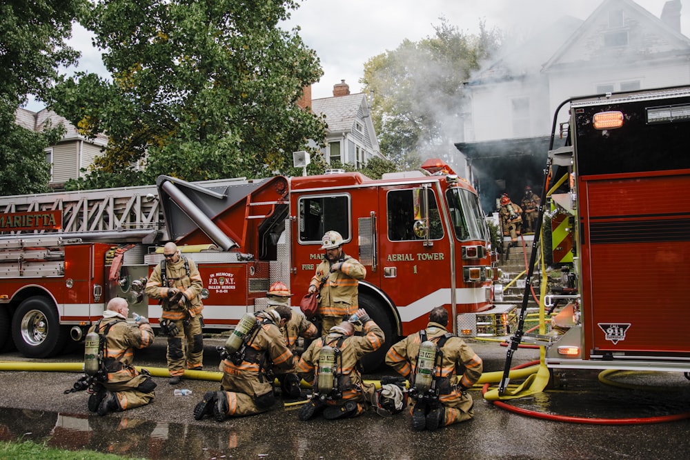 a group of firefighters standing next to a fire truck