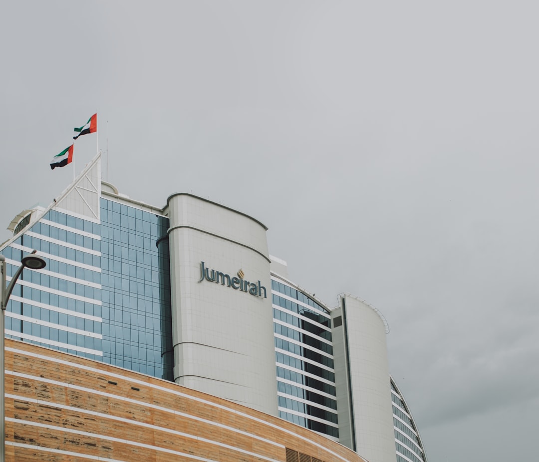 a tall building with a flag on top of it, Modern Dubai buildings architecture landmarks with beautiful view and sky back