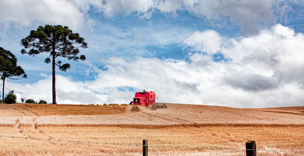 a red truck driving down a dirt road