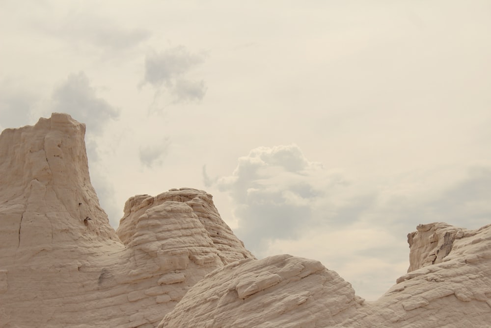 a large rock formation with a cloudy sky in the background