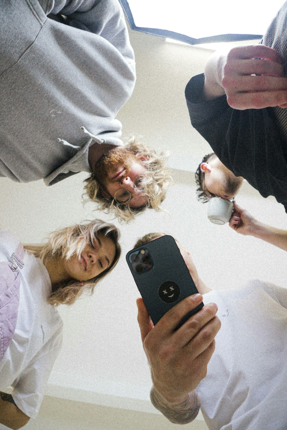 a group of people standing in a circle holding a cell phone
