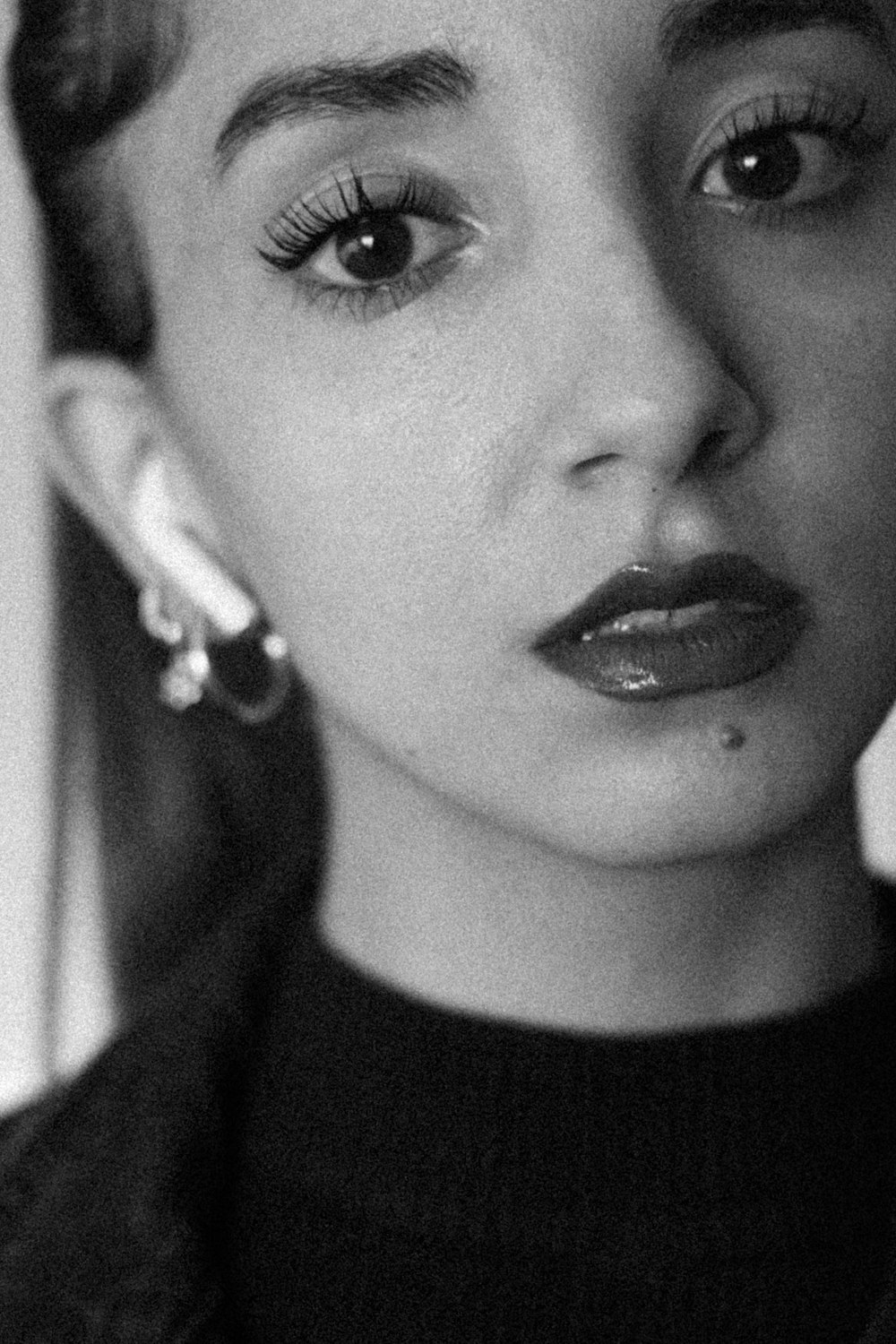 a black and white photo of a woman with long lashes