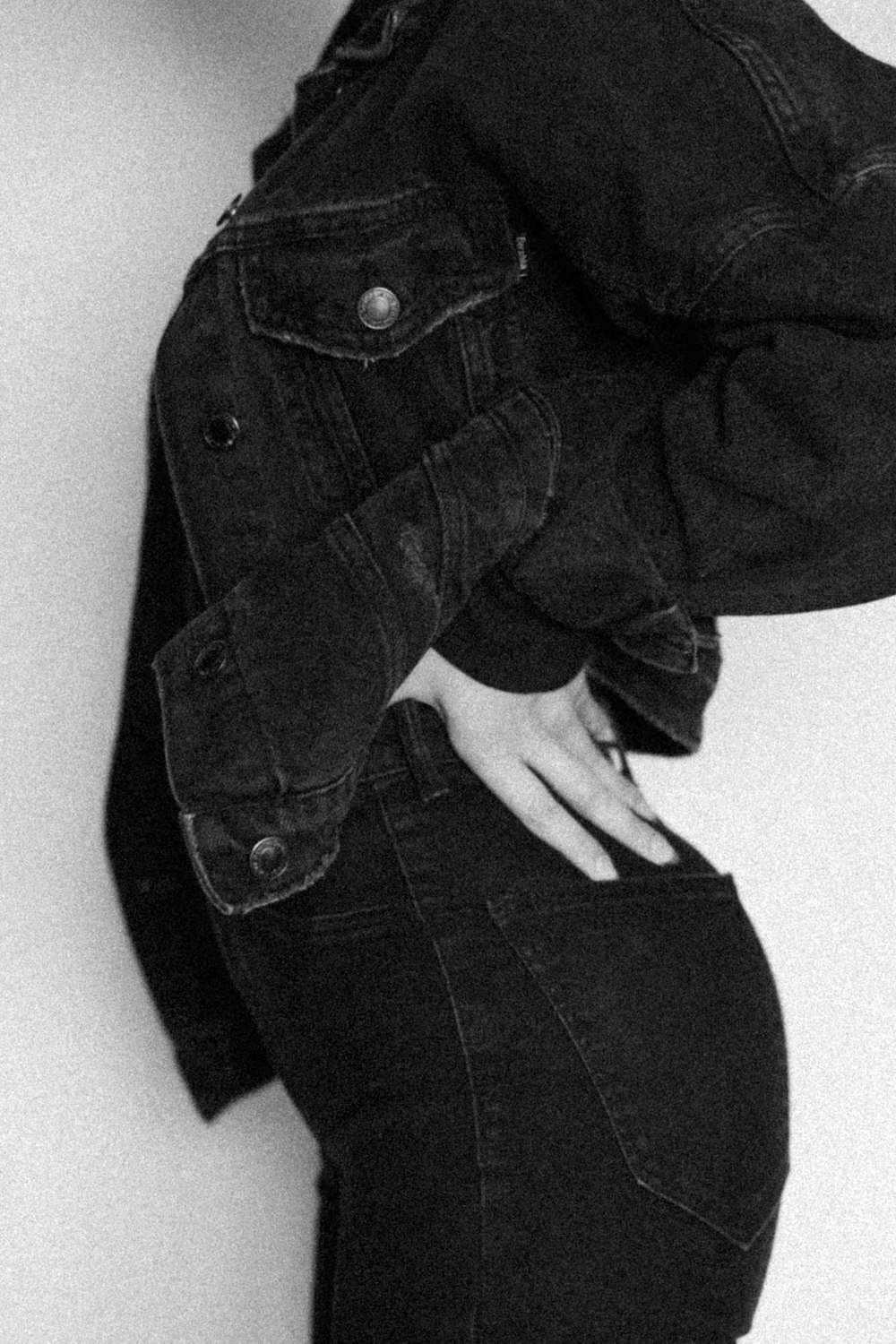 a black and white photo of a woman wearing a jean jacket