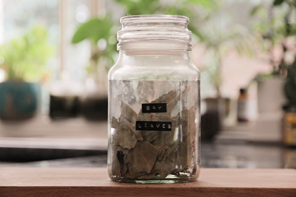 a jar filled with leaves sitting on top of a table