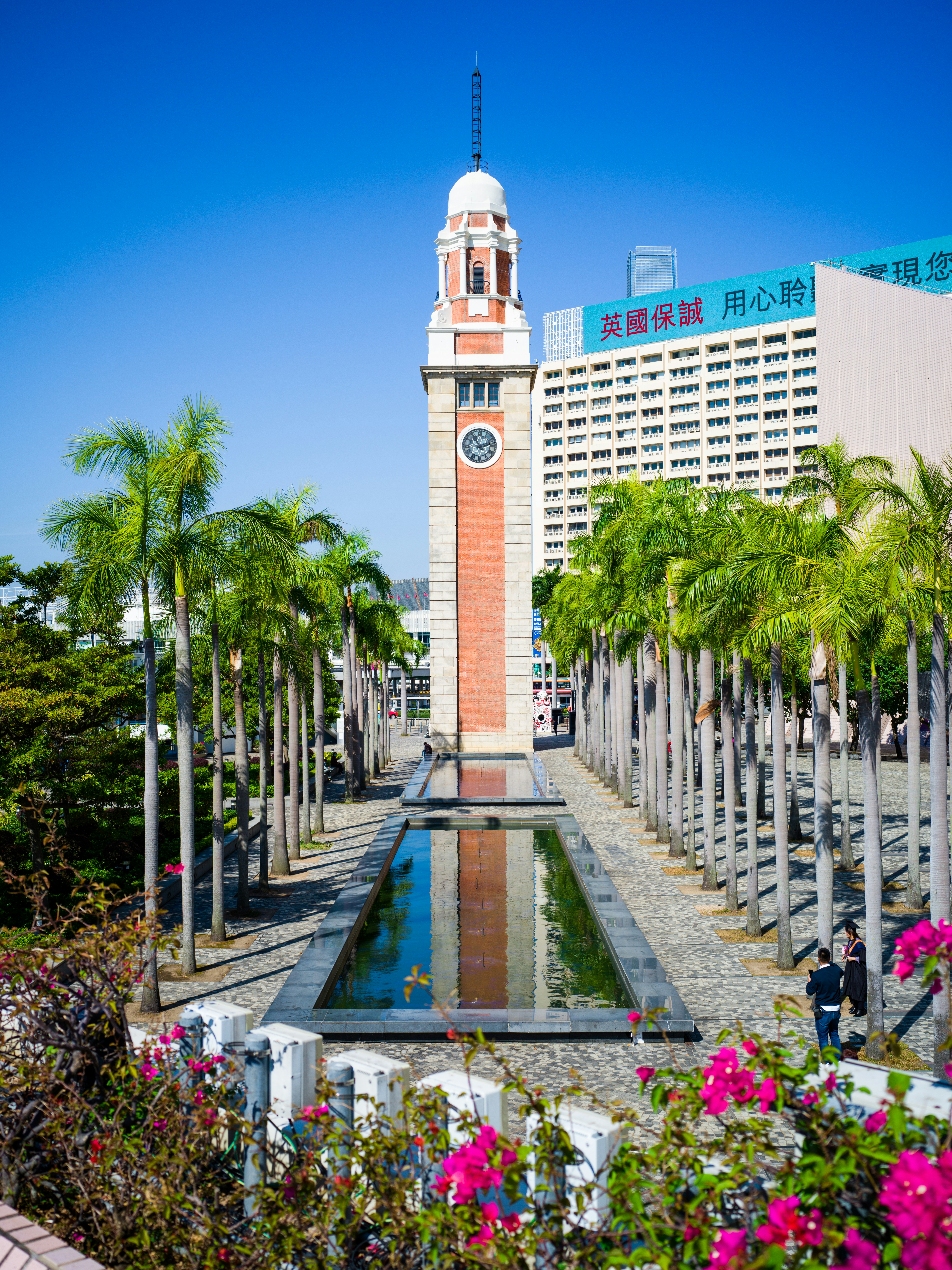 a tall clock tower sitting next to a pool of water