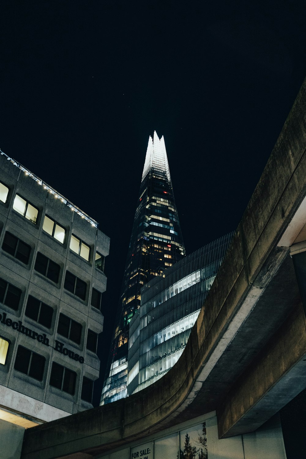 a very tall building towering over a city at night