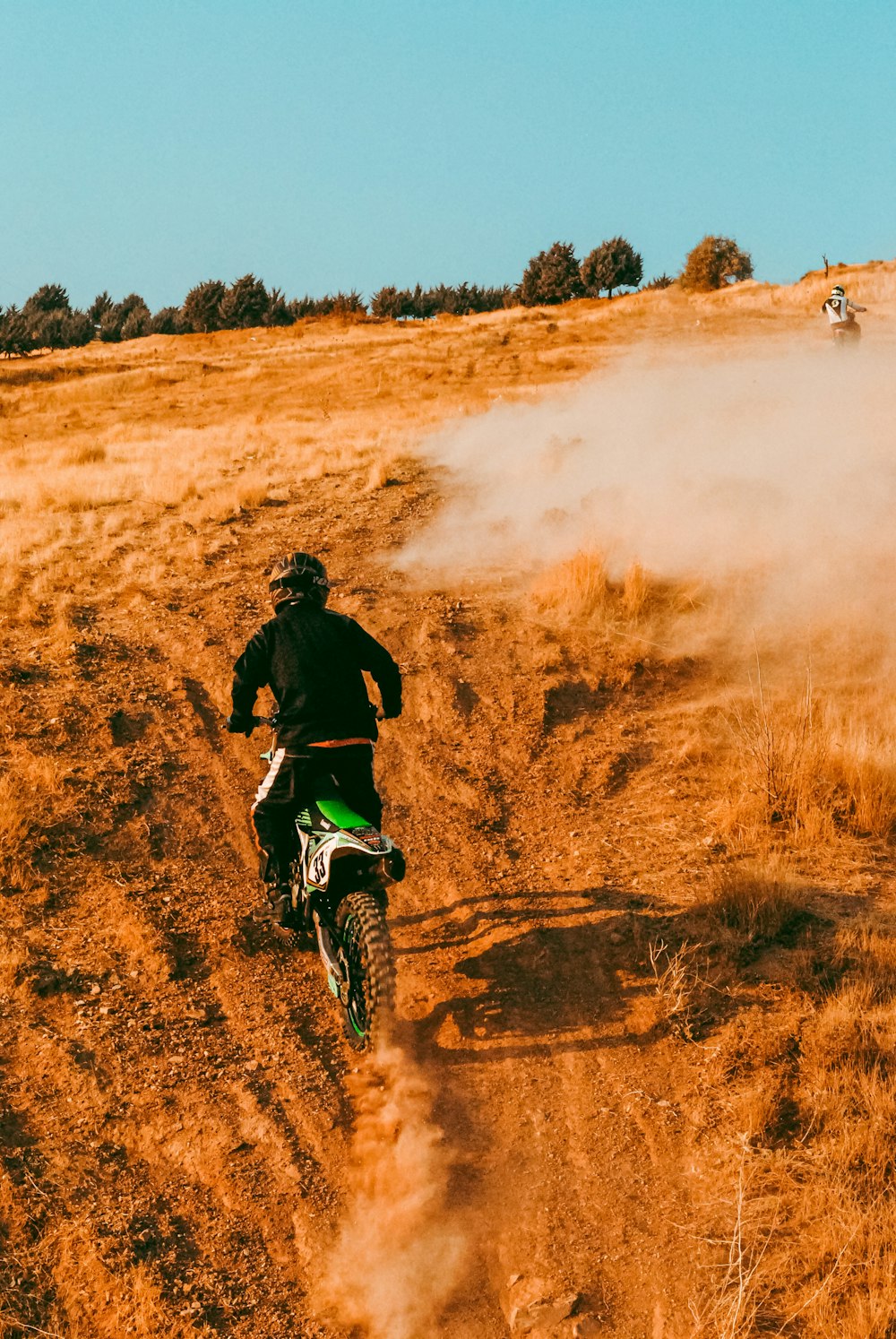 未舗装の道路でダートバイクに乗っている人