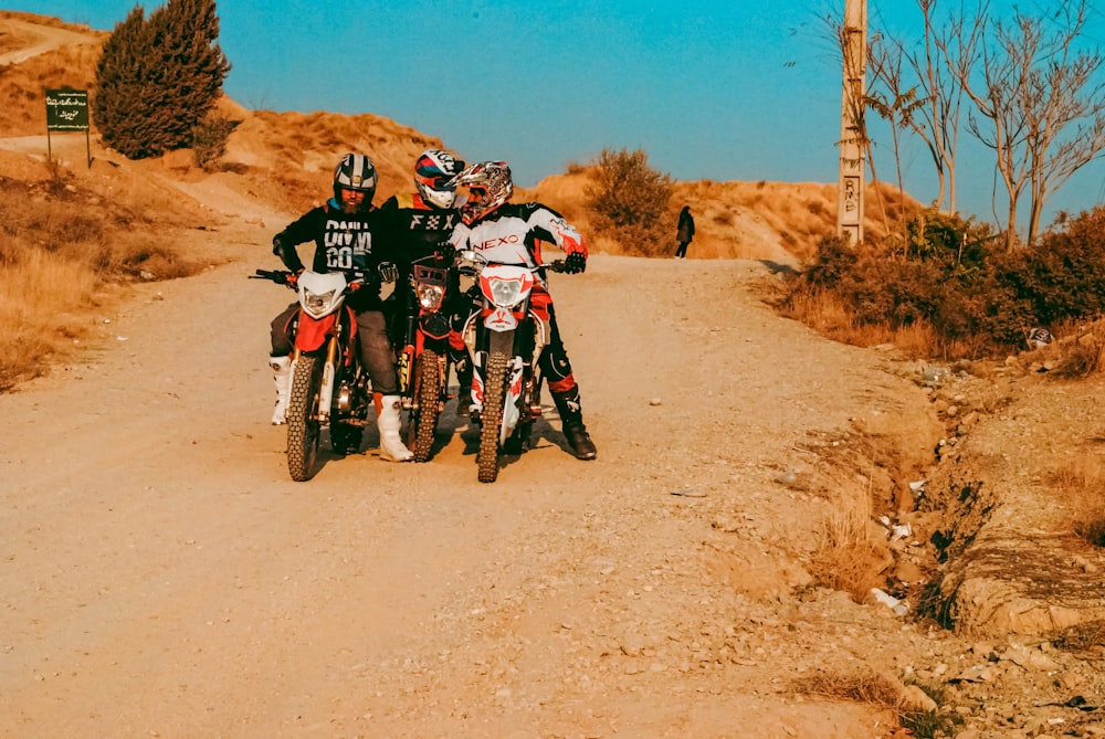 two people on dirt bikes on a dirt road