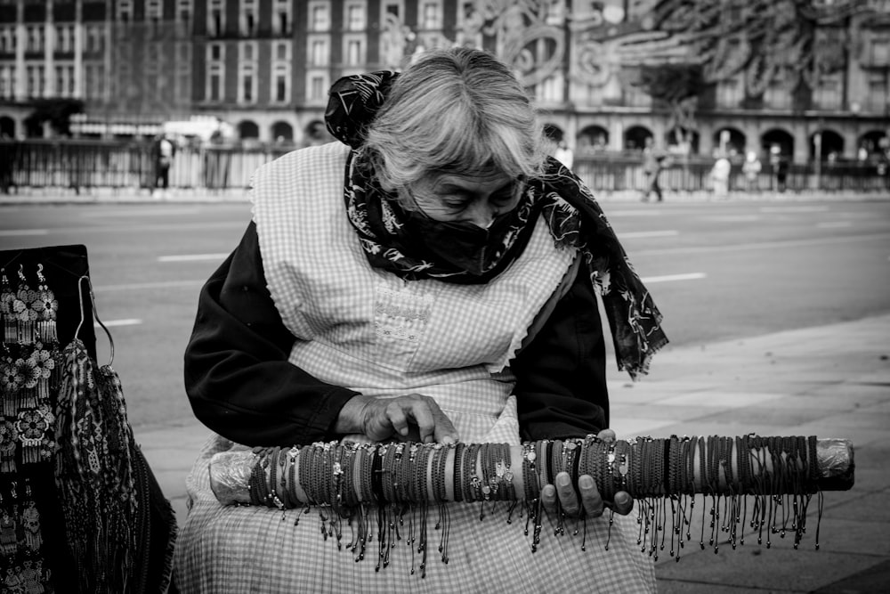 a woman sitting on a bench with a lot of bracelets