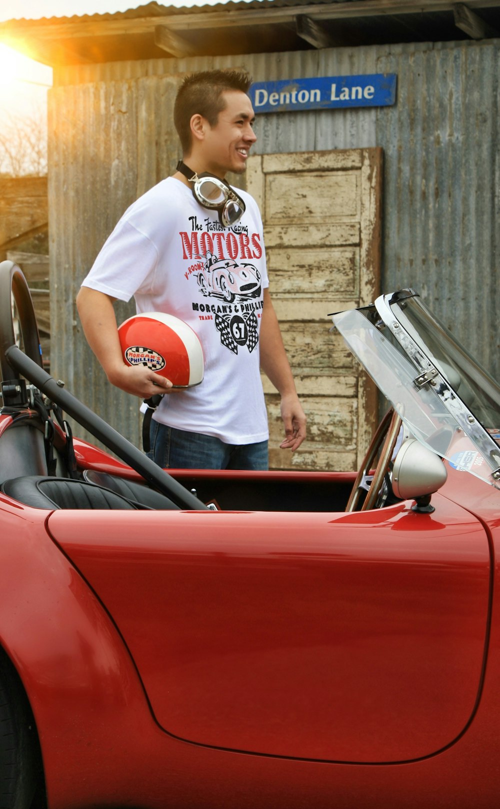 a man standing next to a red sports car