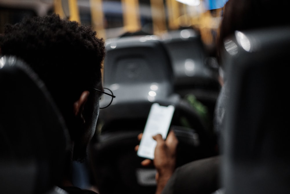 a man sitting in a car holding a cell phone