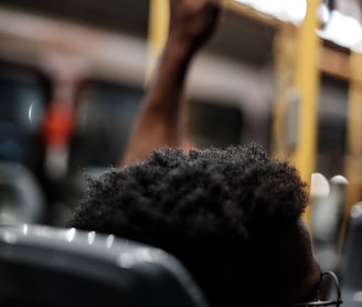 a man sitting on a train holding a cell phone