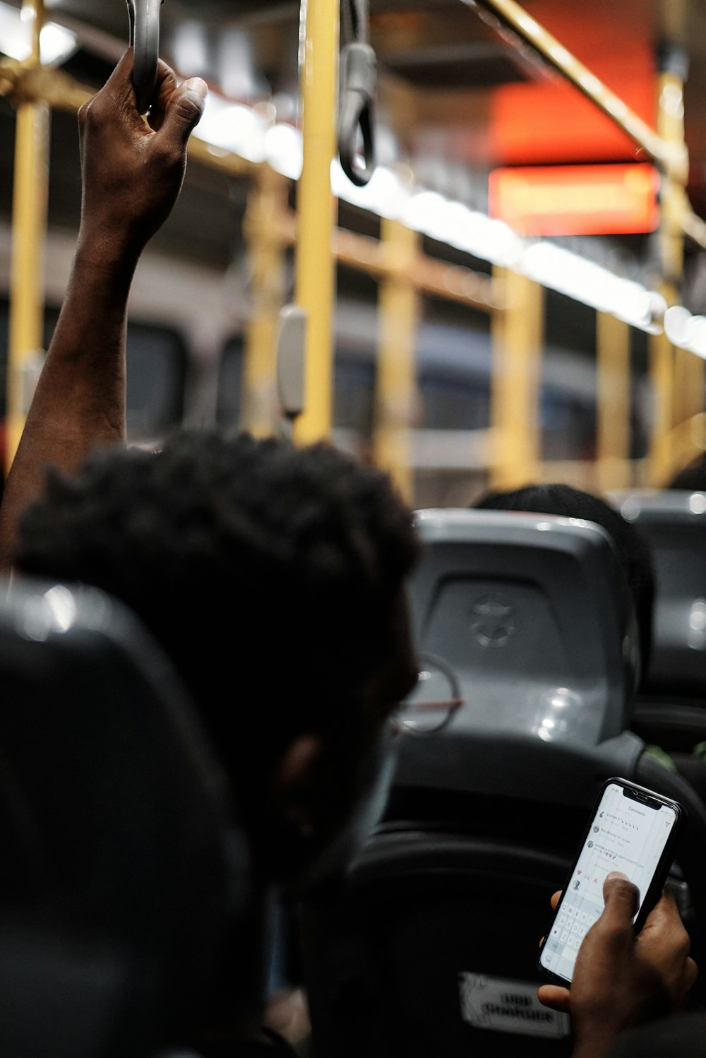 a man holding a cell phone while riding a bus