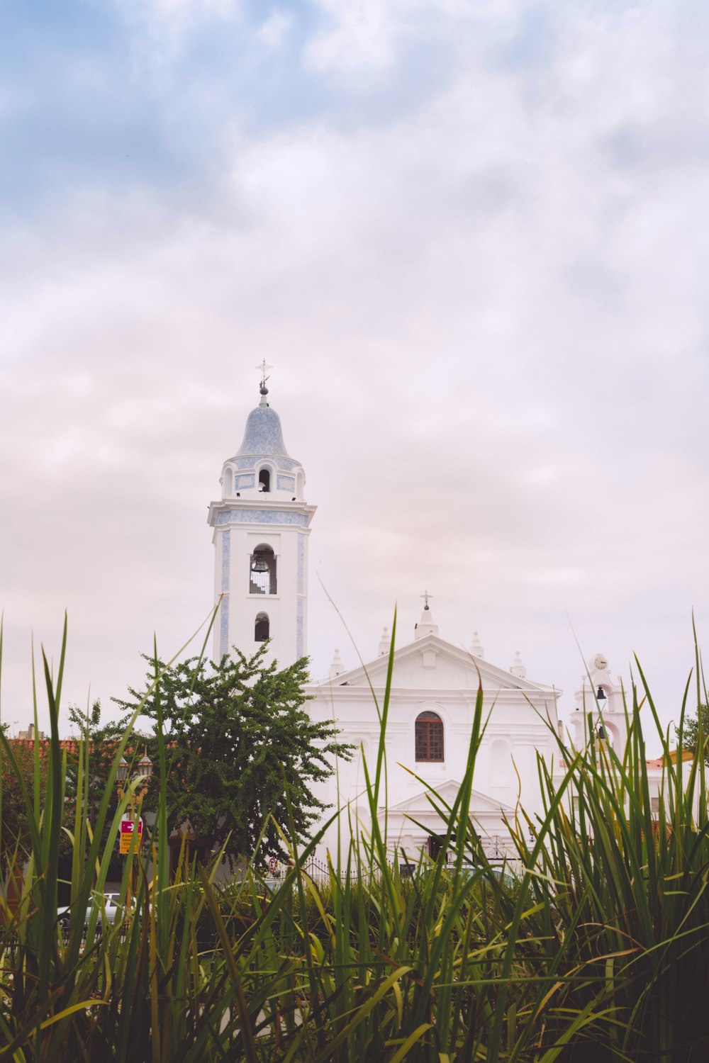 a tall white building with a clock on it's side