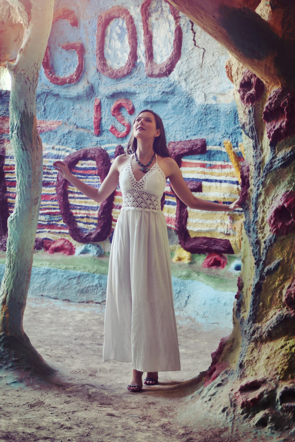 a woman in a white dress standing in front of a sign