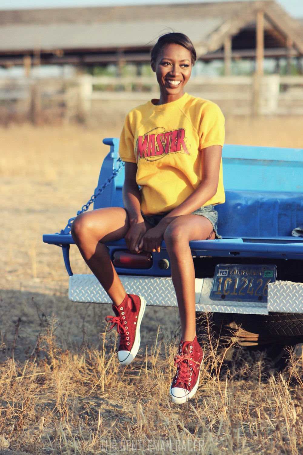 a woman sitting on a blue bench in a field