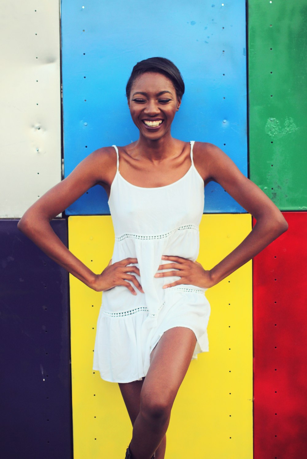 a woman standing in front of a colorful wall