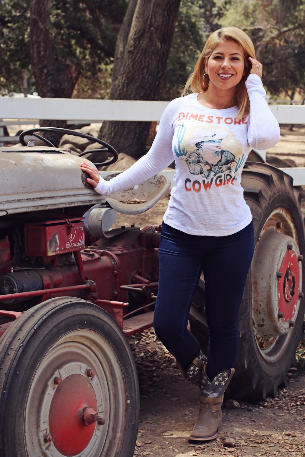 a woman standing next to an old tractor