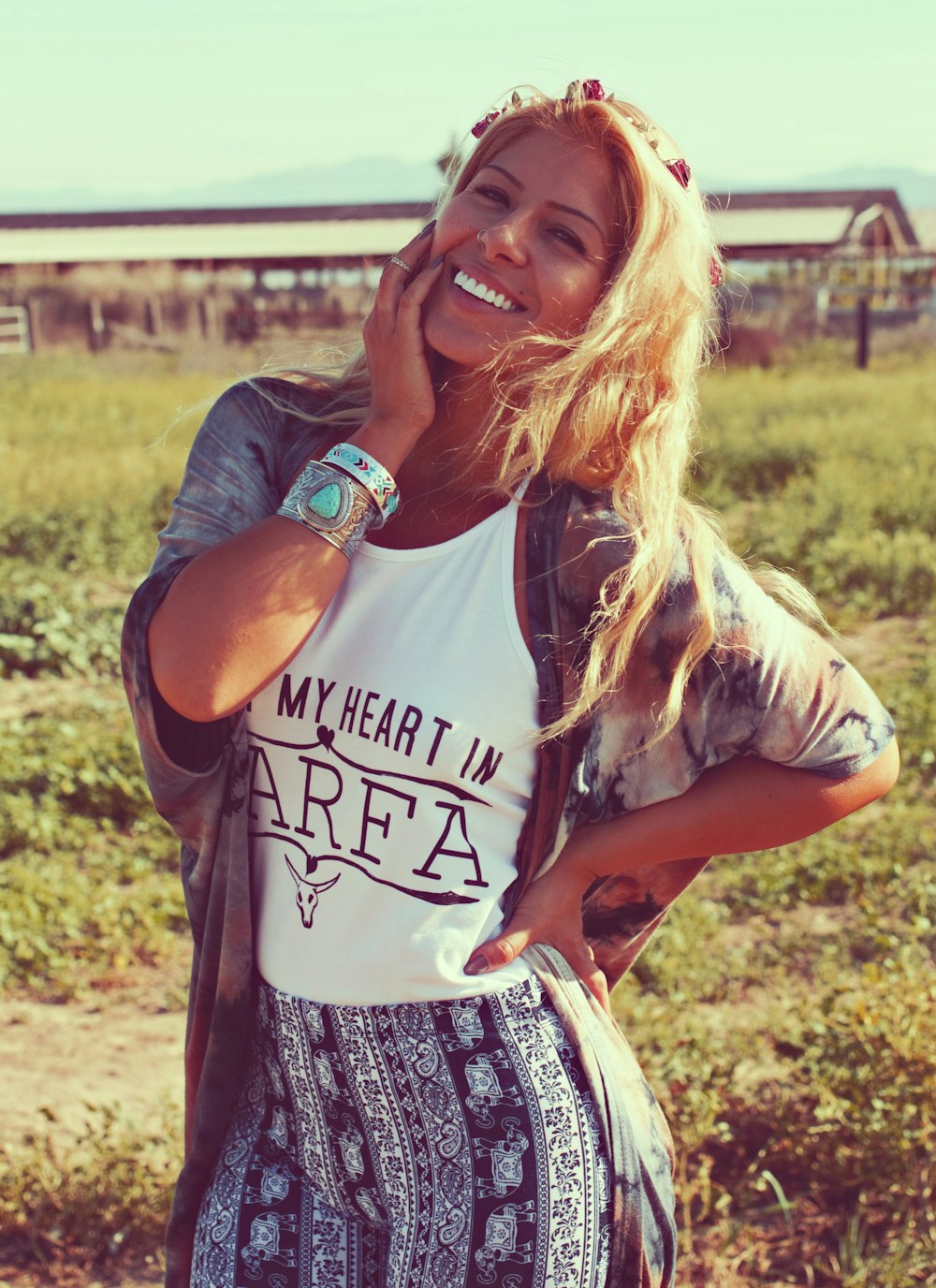 a woman standing in a field talking on a cell phone