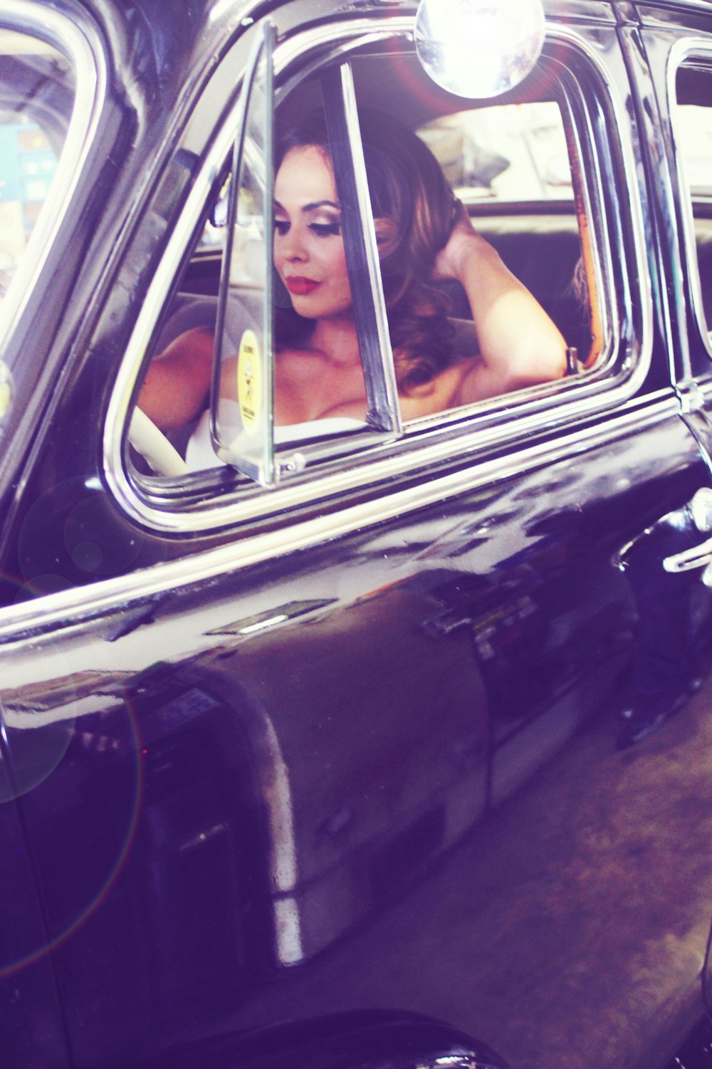 a woman sitting in a car looking out the window