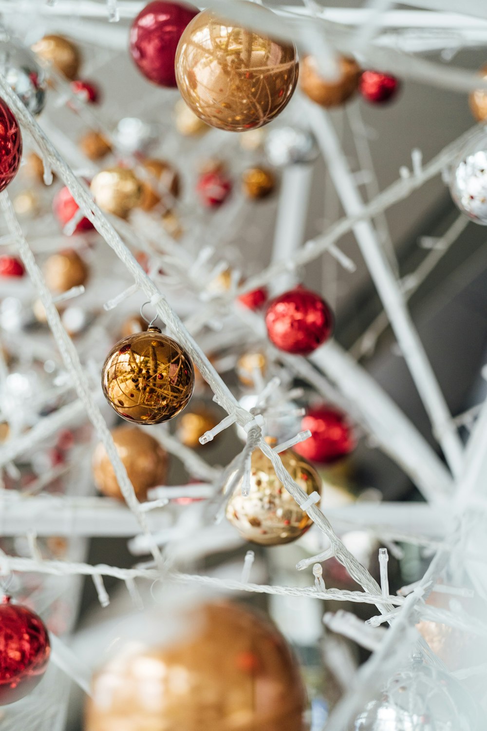 a white christmas tree with red and gold ornaments