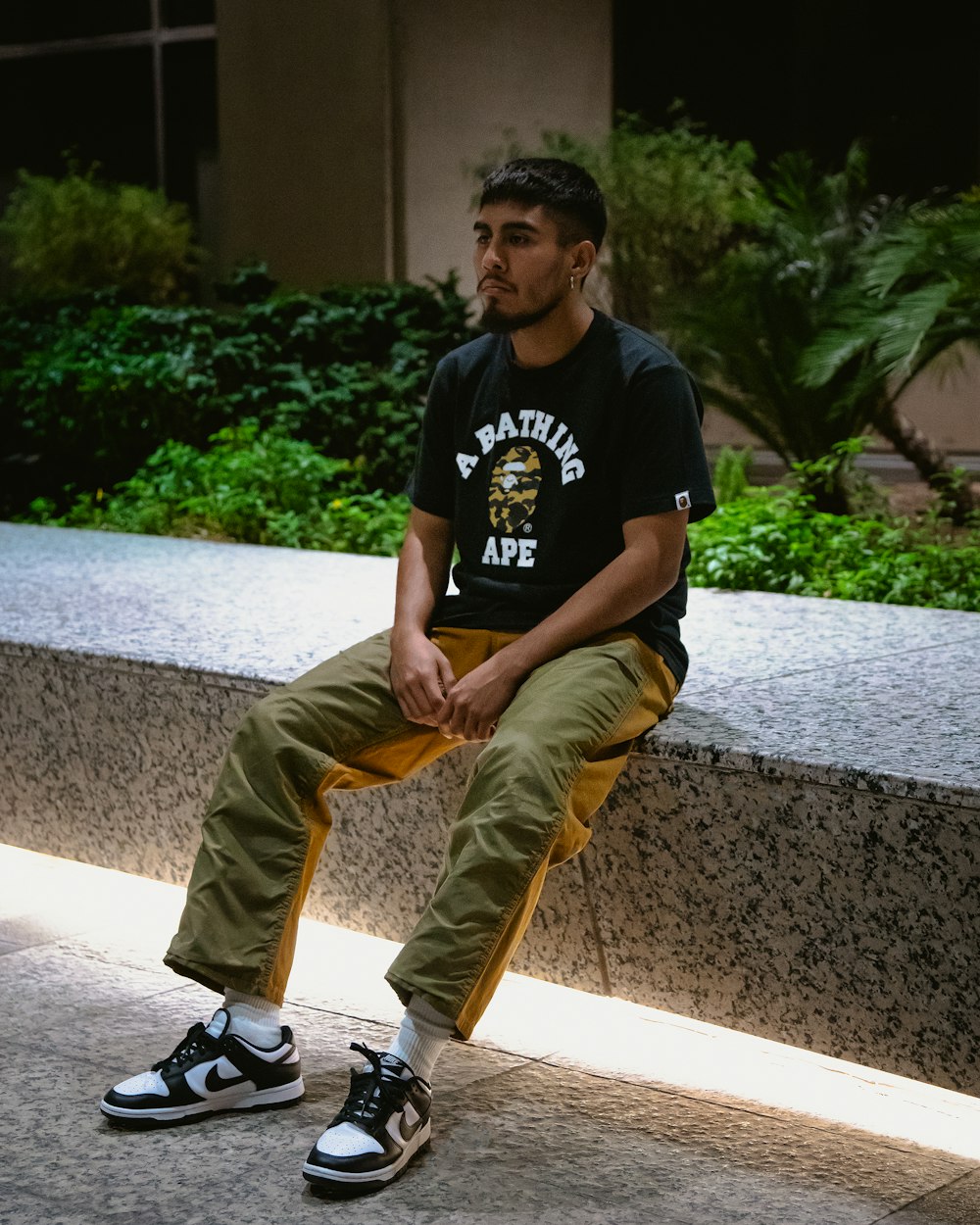 a man sitting on a ledge with his foot on a skateboard