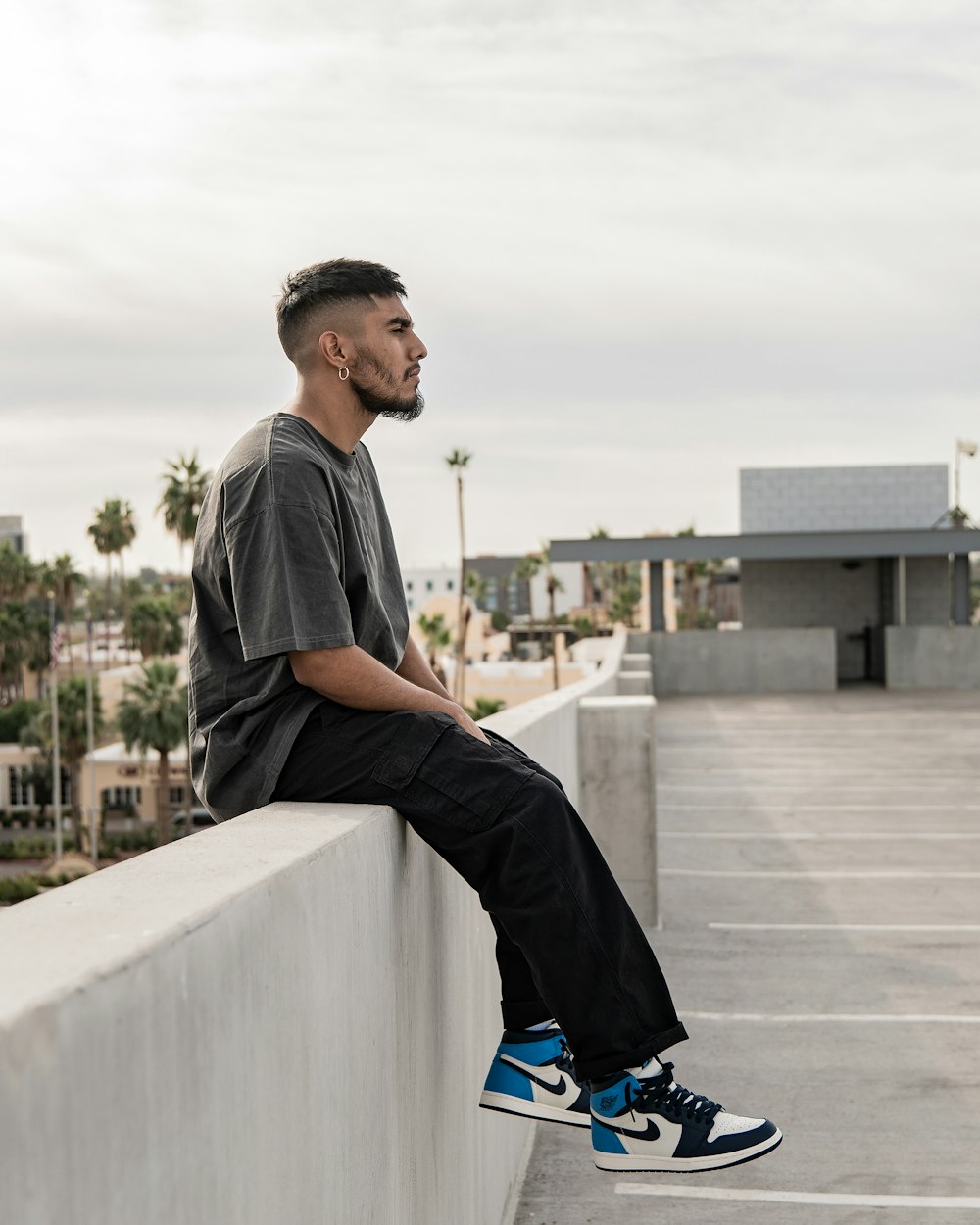 a man sitting on top of a cement wall