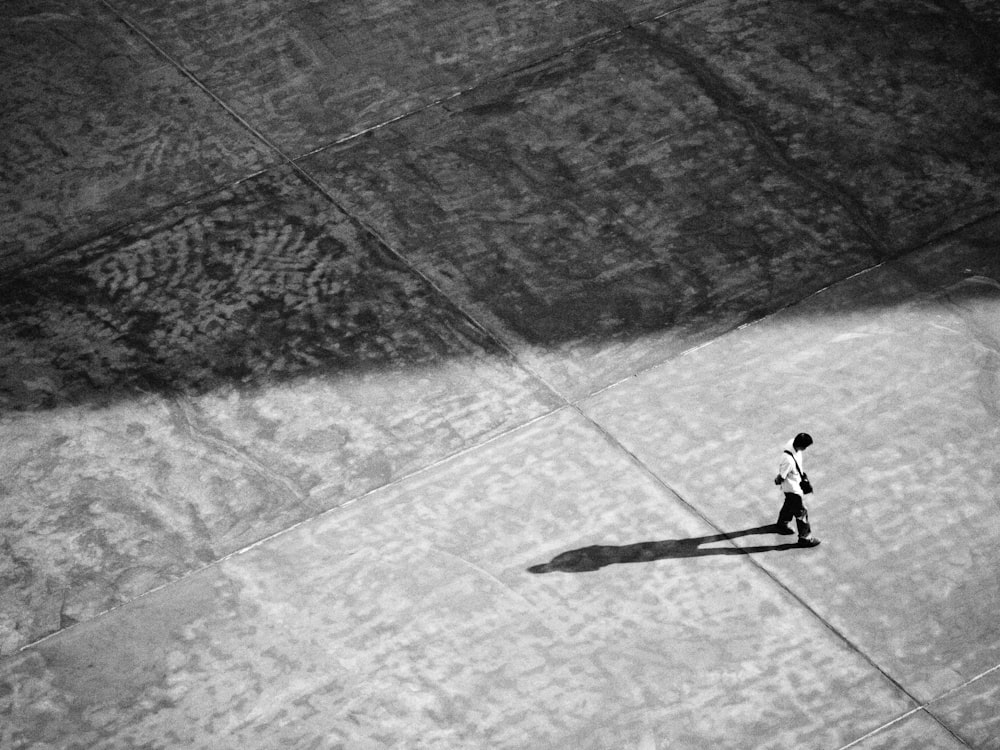 a black and white photo of a person walking