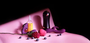 Brightly colored sex health products arranged artistically on a sleek black surface.