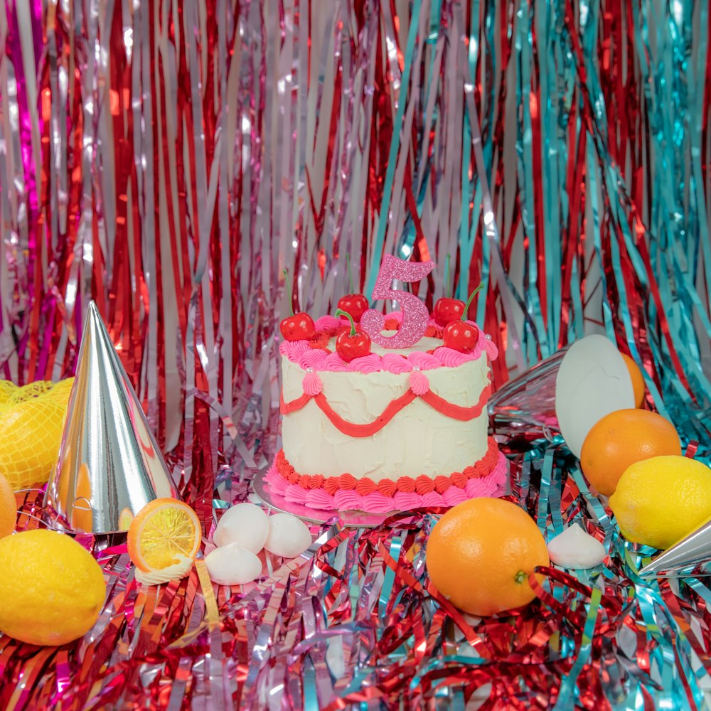 a birthday cake surrounded by fruit and confetti