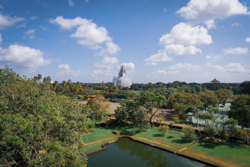 an aerial view of a park with a pond in the foreground