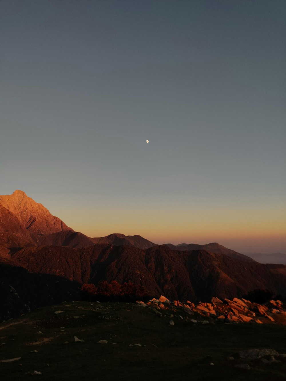 the sun is setting over a mountain range