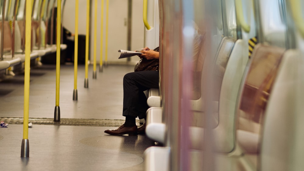 a person sitting on a train with their legs crossed