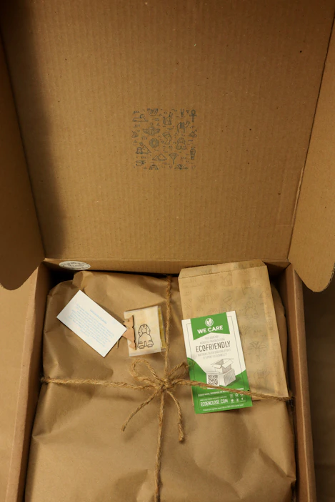 Eco-friendly packaging boxes made from natural fibers arranged on a wooden table with green leaves around