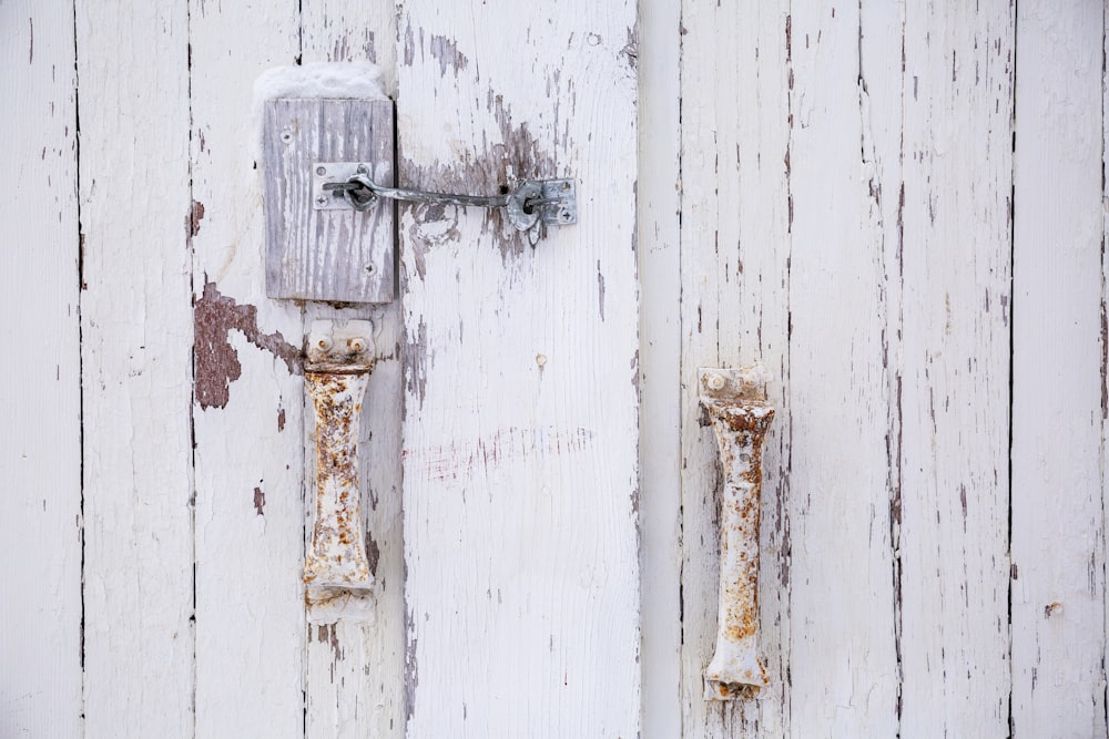 a white door with a rusted handle on it
