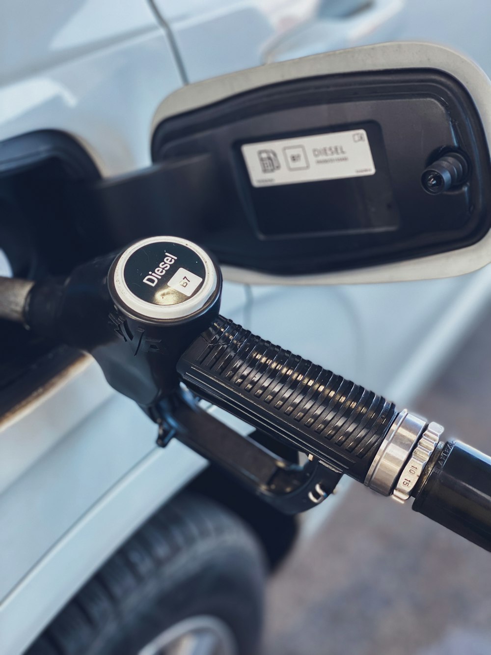 a close up of a gas pump with a car in the background