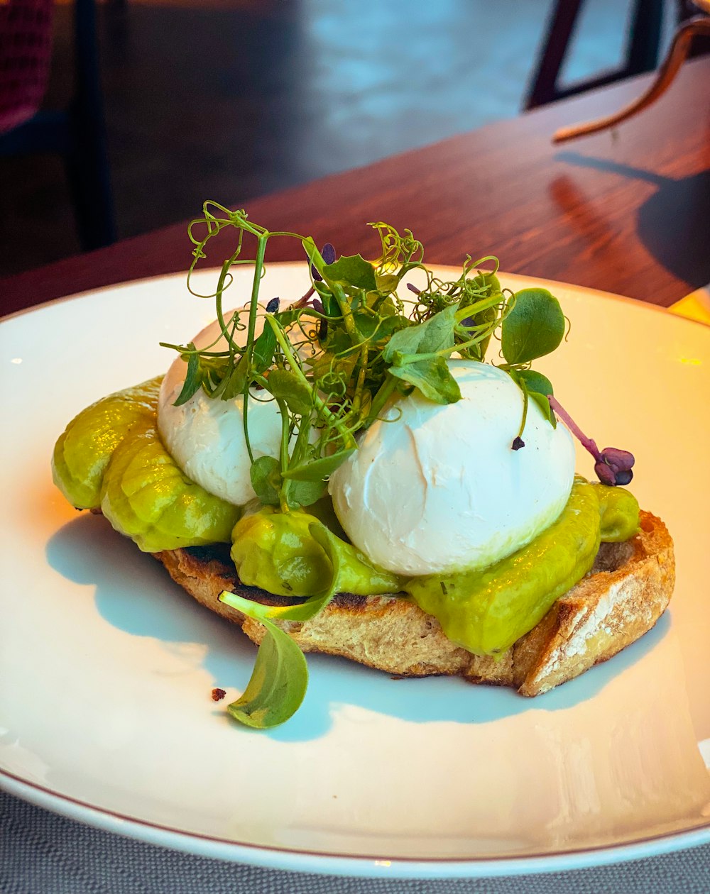 a white plate topped with an open face sandwich