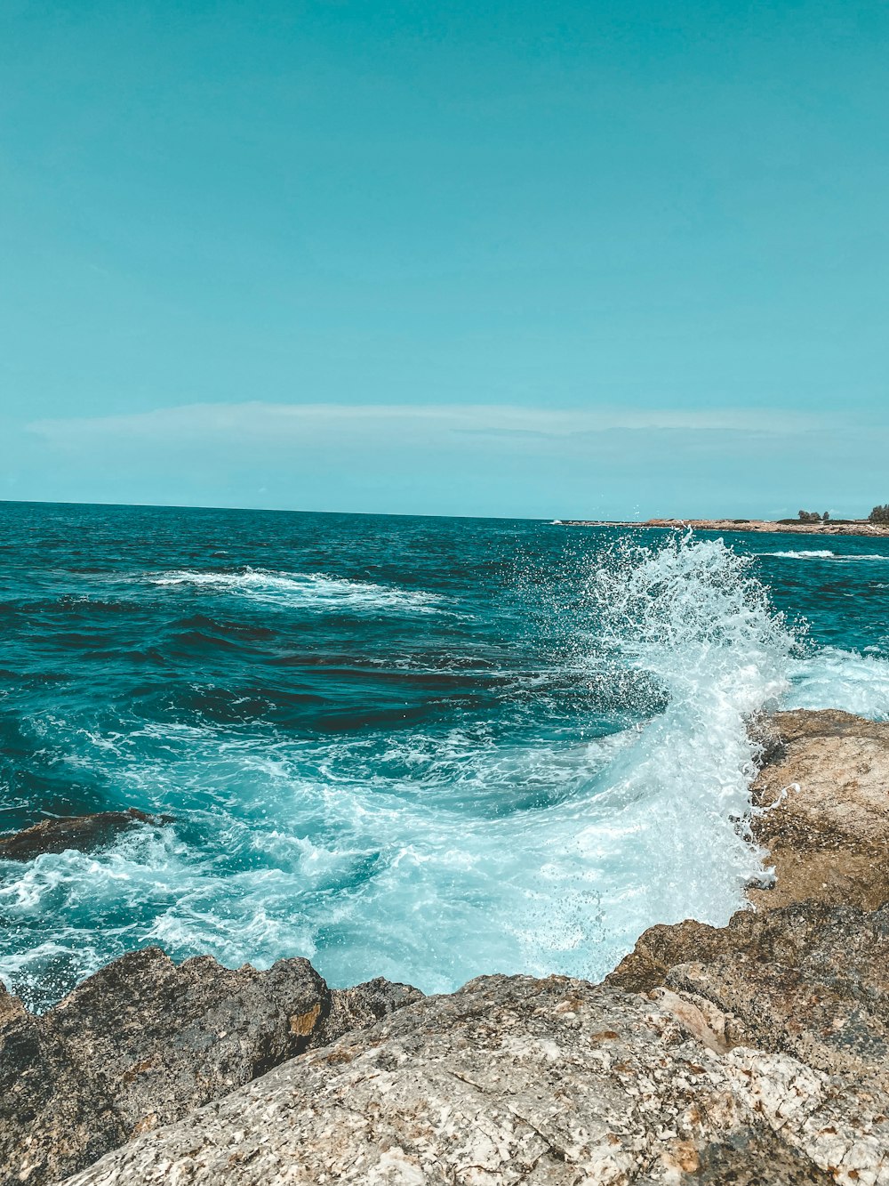 a large body of water sitting next to a rocky shore