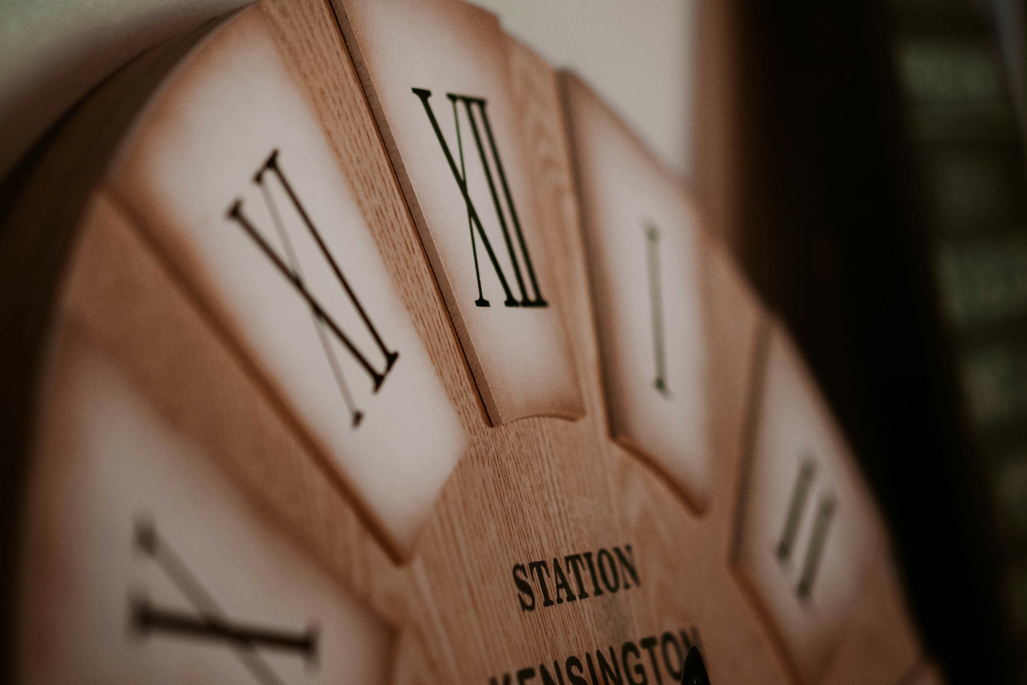 a close up of a wooden clock with roman numerals